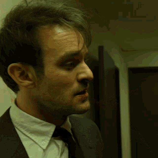 a man wearing a suit and tie has blood on his face
