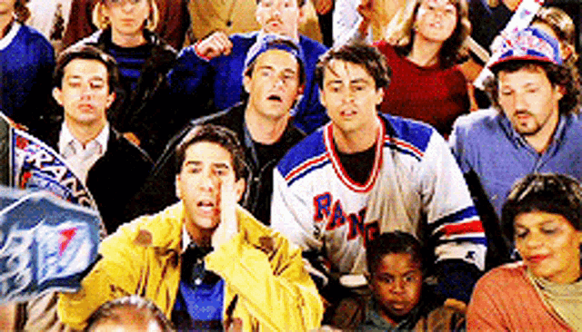 a group of people are watching a game and one of them is wearing a jersey that says rangers