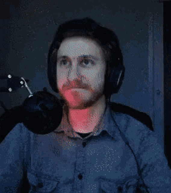 a man with a beard wearing headphones and a microphone .