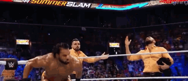 a group of men are wrestling in a ring with a sign that says summer slam behind them .