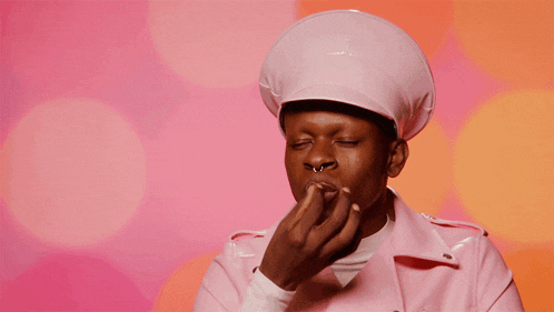a man in a pink chef 's hat and jacket says chef 's kiss