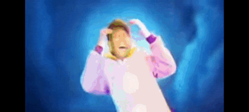 a man in a unicorn costume is standing in a dark room .