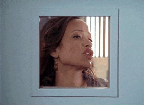 a woman is looking through a window with a white frame