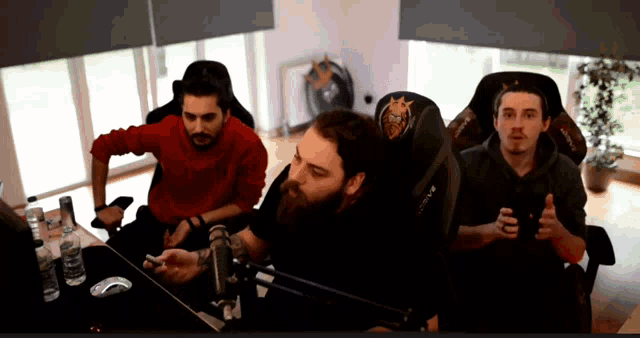 a man in a red sweater sits in a chair with a crown on it