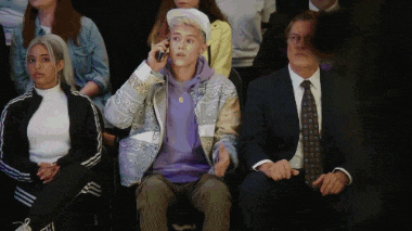 a man in a purple jacket talks on a cell phone