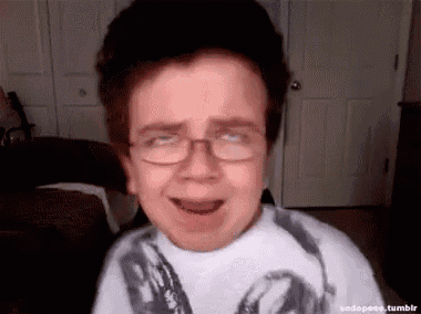a young boy wearing glasses is crying in a living room .