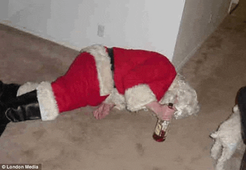 a man dressed as santa claus is laying on the floor