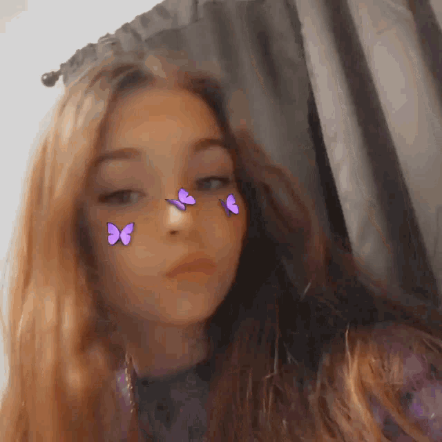 a girl with long hair and purple butterflies on her face