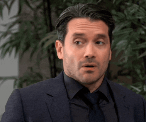 a man in a suit and tie is making a funny face