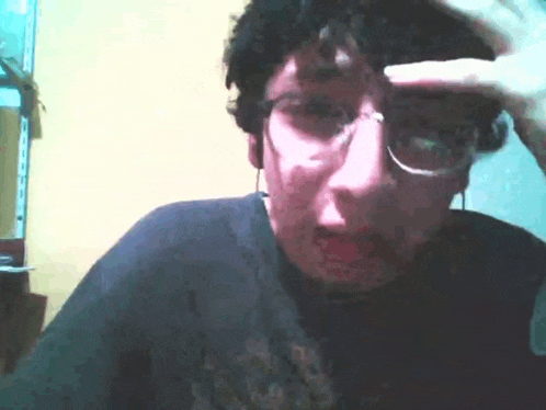 a man wearing glasses and ear buds is making a funny face