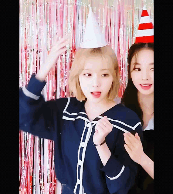 two girls wearing party hats are posing for a photo