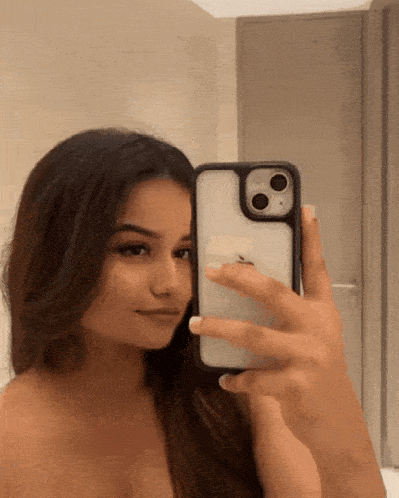 a woman taking a picture of herself in the mirror