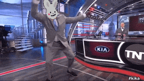 a man in a suit is dancing in front of a kia logo