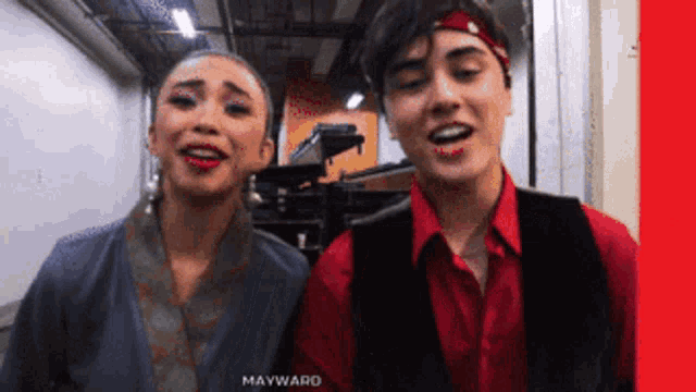a man and a woman standing next to each other with mayward written in the corner
