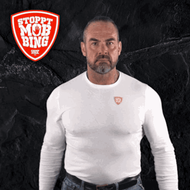 a man wearing a white shirt with a sticker that says stoppt mob bing on it