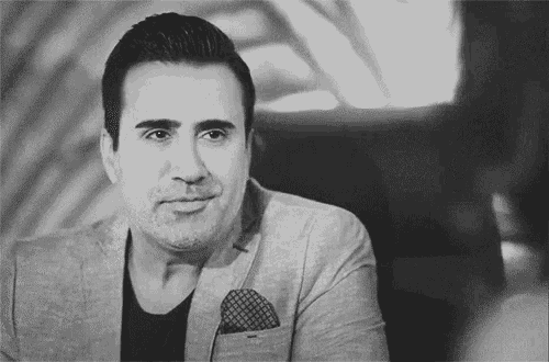 a black and white photo of a man in a suit with a pocket square .