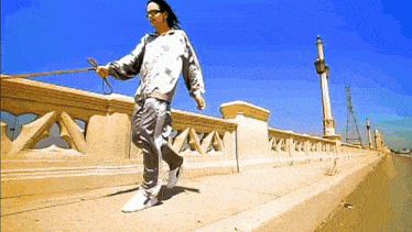 a man is walking a dog on a leash across a bridge