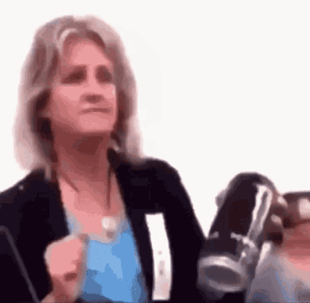 a woman is holding a bottle of monster energy drink in her hand .