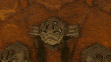 a statue with a face on it is sitting on a rocky surface