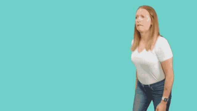 a woman in a white t-shirt and blue jeans is dancing on a blue background
