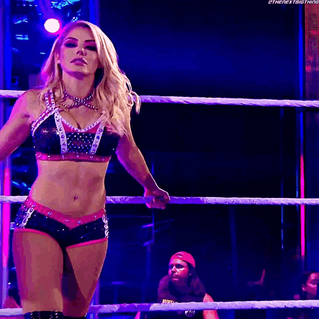 a woman is standing in a wrestling ring with the next thing written on the bottom right