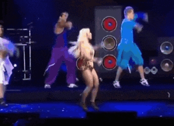 a group of people are dancing on a stage in front of a speaker