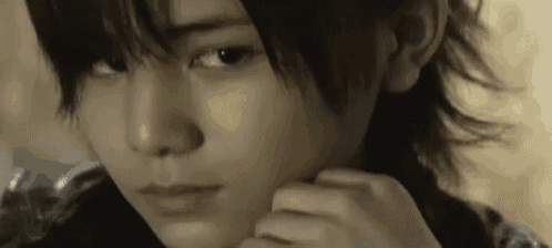 a close up of a person 's face with their hand on their face .