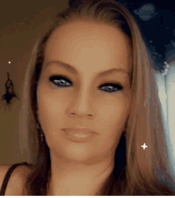 a close up of a woman 's face with a cross on her ear