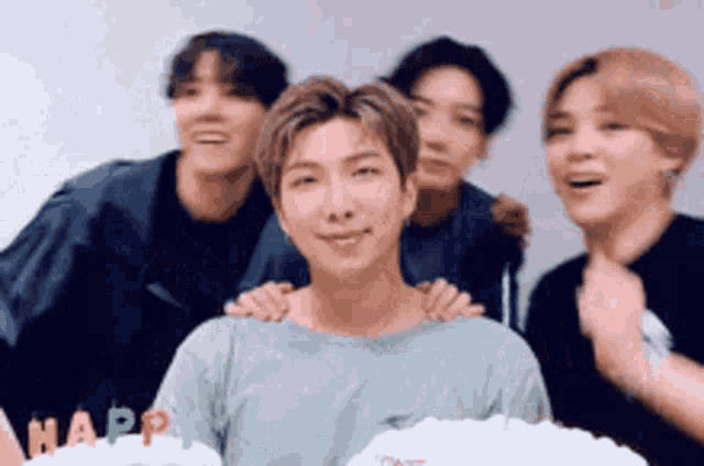 a group of young men are posing for a picture with a cake that says happ
