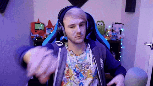 a man wearing headphones and a hoodie is sitting in a gaming chair