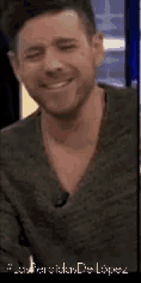 a man with a beard is smiling for the camera .