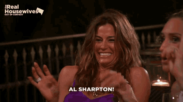 two women are laughing in front of a real housewives sign