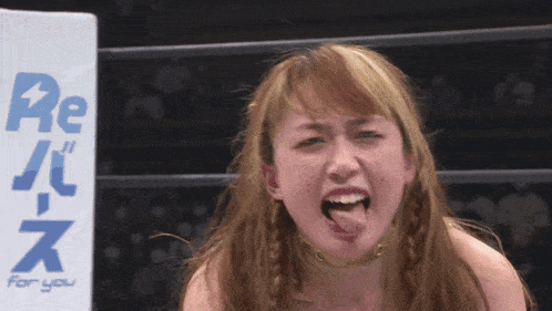 a woman is sticking her tongue out in front of a banner that says re for you