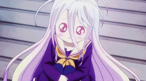 a girl with white hair and big red eyes is sitting down with her arms crossed .
