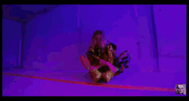 a man wearing sunglasses is driving a car with purple lights on .