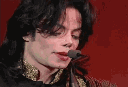 a close up of a man 's face with a microphone in his mouth .