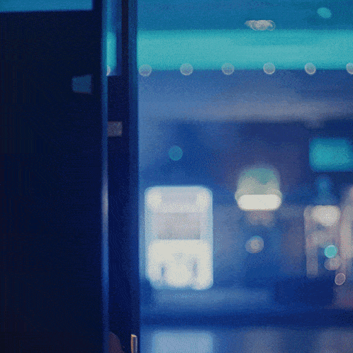 a blurred image of a building with a blue light behind a door
