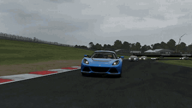 a blue sports car is driving down a track