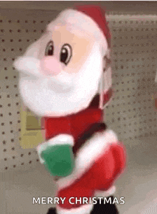 a stuffed santa claus is holding a cup of hot chocolate and says merry christmas .