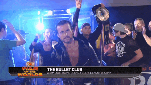 a man is holding a trophy in front of a sign that says " the bullet club "