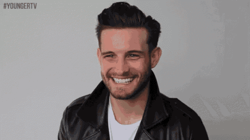 a man wearing a black leather jacket is smiling for the camera