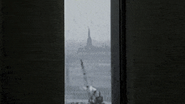 a window with the statue of liberty in the background and a few icons on it