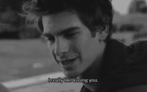 a black and white photo of a man smiling and saying i really like kissing you .