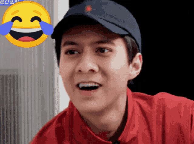 a man wearing a hat and a red shirt is laughing with tears running down his face