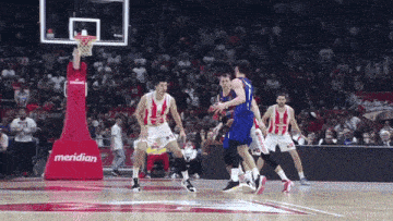 a basketball game is being played in front of a red meridian sign