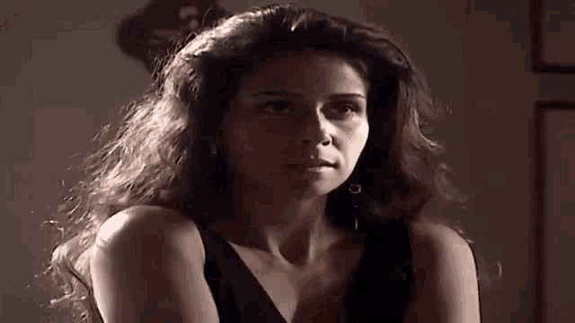 a woman with long hair is wearing a black tank top