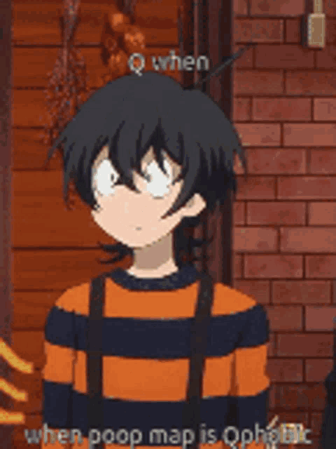 a boy in an orange and black striped sweater is standing in front of a brick wall .