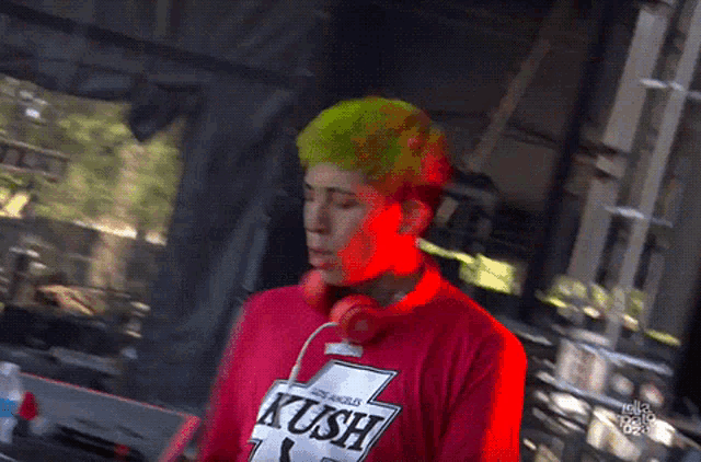 a man with green hair is wearing a pink shirt that says ' i love you ' on it