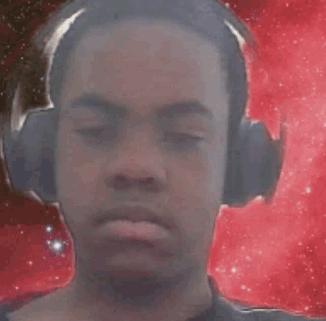 a man wearing headphones with a red background behind him