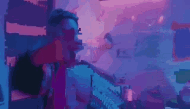 a man is holding a gun in front of a purple and blue background .